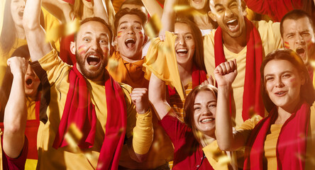 Spanish emotive football, soccer fans cheering their team with a red scarfs at stadium stands. Concept of sport, emotions, team event, competition. © master1305