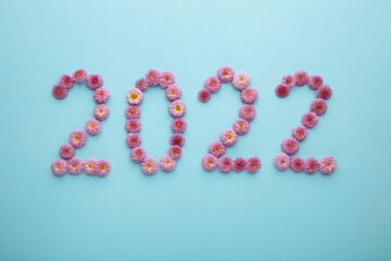 2022 made from fresh flowers on blue background. Happy New Year decoration.