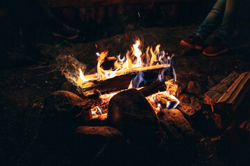  A bonfire on the floor. A burning log. The fire is fenced with stones.