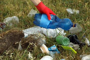 Woman in gloves collecting garbage in nature, closeup