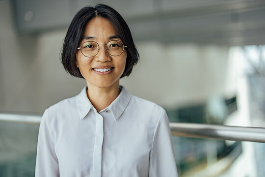 Smiling adult asian woman, representing her company