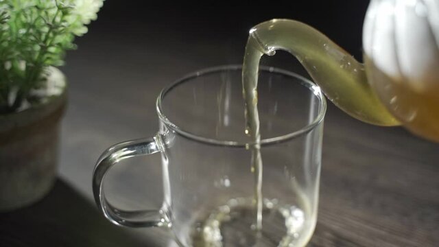 温かいお茶をコップに注ぎ、湯気が出ている