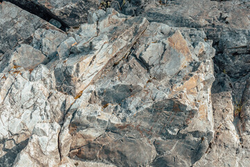  The texture of the rock. A light gray rock with a marble risoncum. Lichen on the rock. Texture. A screen saver for the desktop.