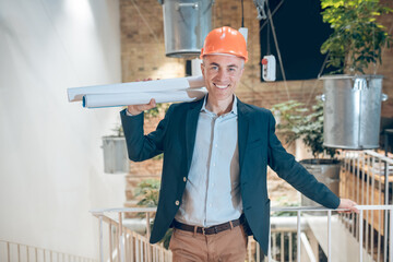 Confident man with drawings standing on stairs