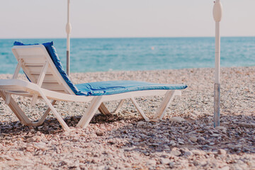 Empty sunbead on scenic beach. Vacation in Europe.