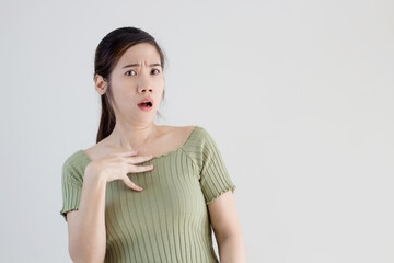 Asian beautiful women wear green t-shirt use hand touch her chest with shocked and surprised face when get good and bad news or an information or promotion