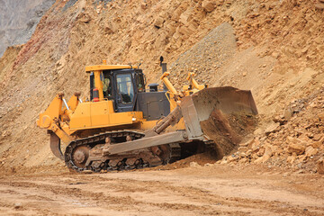 Obraz premium Bulldozer workflow for laying or leveling a technological road in a mining quarry