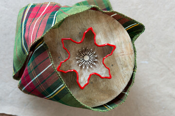 snowflake or star shaped cookie cutter on spool with cloth ribbon and ornament viewed from above