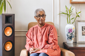 Portrait of an elderly black woman sitting in a chair in her living room