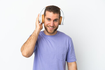Young handsome caucasian man isolated on white background listening music