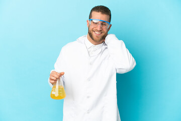 Young caucasian scientific man isolated on blue background laughing