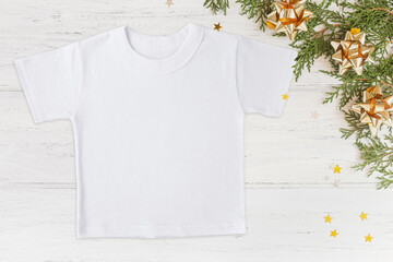 Christmas white t-shirt mockup with Christmas decorations and bokeh on wooden background, mockup, flat lay, copy space