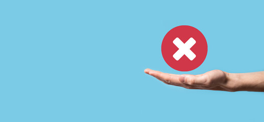 Hand holds icon,cancellation symbol,cancel icon.Cross mark flat red icon.round X mark.cancel button.Wrong.cross mark rejection.Declined.On dark background.Banner.Copy space.Place for text.