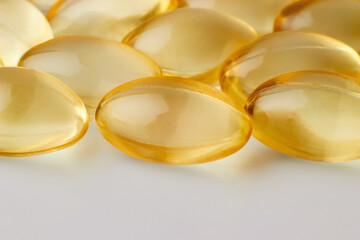 Vitamin D capsules in a close up on a light background.