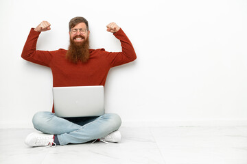 Young reddish caucasian man with laptop isolated on white background doing strong gesture