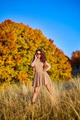 Fototapeta na wymiar a beautiful elegant woman posing on a sunny autumn day.