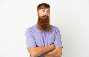 Obraz premium Young reddish caucasian man isolated on white background making doubts gesture while lifting the shoulders