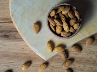 Bowl with delicious almonds on a wooden table