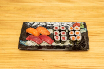 Tray of mixed sushi with Norwegian salmon nigiri and red tuna and maki with rice and Japanese vinegar, nori seaweed, canned wasabi with ginger