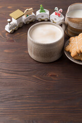 Coffee with milk and gingerbread cookies on wooden background. Winter hot drinks.