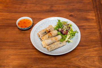 Vietnamese nems, a simple, exotic and crunchy bite of rice paper wafer stuffed with prawns with salad and sweet and sour sauce