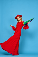 woman in red dress multicolored umbrella blue background