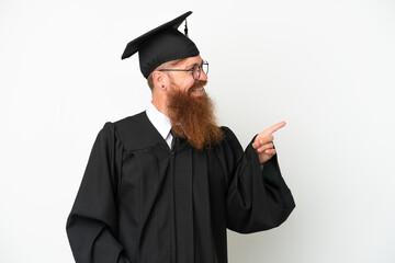 Young university graduate reddish man isolated on white background pointing finger to the side and presenting a product