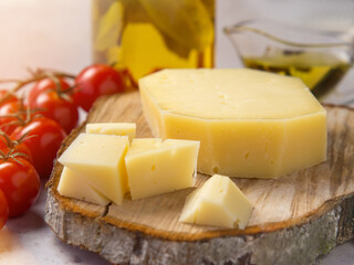 Homemade healthy food concept: cherry tomatoes, cheese slices and olive oil on light concrete background