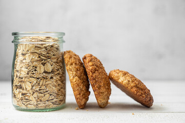 Oat cookies, healthy sweet homemade dessert and a jar with oats on bright background