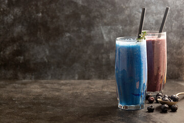 Smoothie glasses with spirulina powder. Fresh banana, blueberry healthy detox drinks.