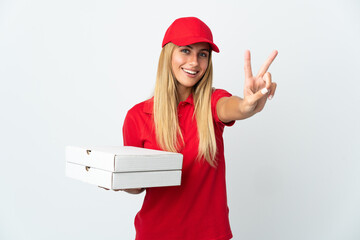 Pizza delivery woman holding a pizza isolated on white background smiling and showing victory sign