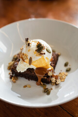 Demonstration of the finished dish. Dessert brownie with ice cream and caramel, granola