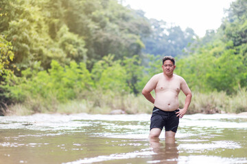 Fat Asian man standing alone in the river