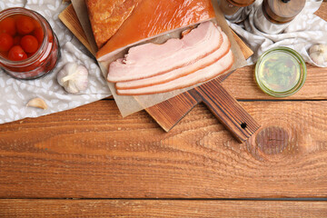 Flat lay composition with delicious smoked bacon on wooden table, space for text
