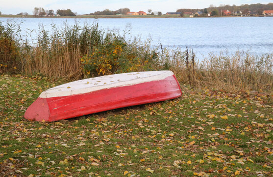 weathered wooden boat upside down on the lawn at the waterside at the baltic sea
