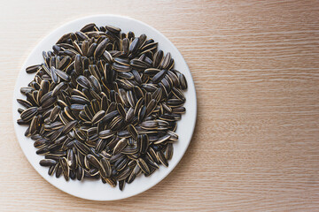 Close-up of a pile of roasted sunflower seeds on a wooden table. Seeds of sunflowers  - protein-rich food, good for health