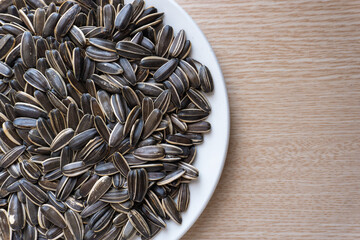 Close-up of a pile of roasted sunflower seeds on a wooden table. Seeds of sunflowers  - protein-rich food, good for health