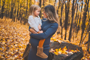 pregnant mother and child on autumn nature outdoors