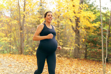 Fit pregnant woman standing outside on a sunny day