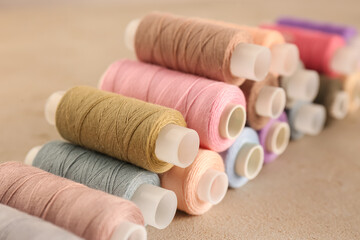 Fototapeta na wymiar Set of color sewing threads on grey table, closeup