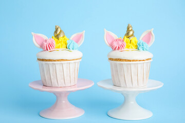 Cute sweet unicorn cupcakes on light blue background