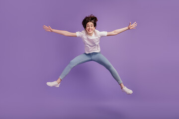 Full size photo of excited young girl jump air have fun travel dream isolated on violet color background