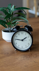 black alarm clock on a wooden table