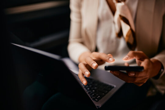 Close-up Of Businesswoman Uses Smart Phone And Laptop While Commuting To Work In A Car.