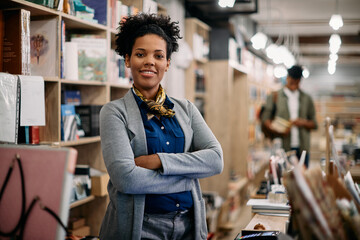 Portrait of confident African American bookstore owner looks at camera.