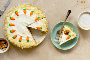 Carrot cake with walnuts an whipped cream, homemade easter cake baking, top view. Whole round cake.