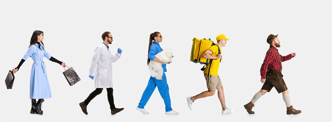 Group of gender mixed people with different professions, jobs walking ahead isolated on white studio background.