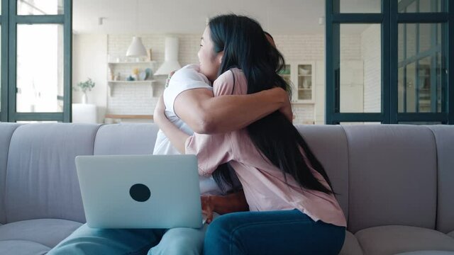 Excited happy multiracial couple looking at screen of laptop feel winners surprised by lottery betting winning bid. Lovely boyfriend and girlfriend celebrating internet lottery victory prize good news