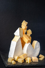 Fototapeta premium cheese plate assorted cheeses aperitif antipasto brie, camembert, cheddar, parmesan and others ready to eat meal snack on the table copy space food background rustic. top view