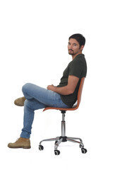 side view of a full portrait of man sitting on chair looking at camera and legs crossed on whige background